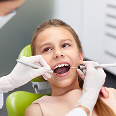 Dentysta bada zęby dziewczynki